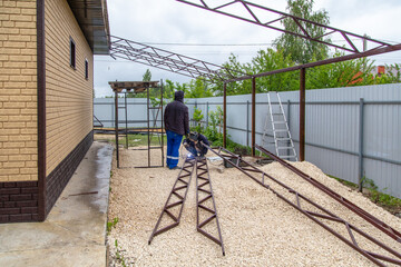 A worker installs metal spans at a construction site.
