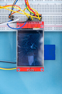 TFT display on breadboard with wires on blue background 