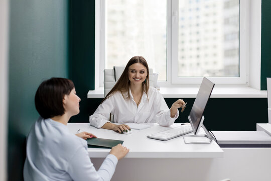 Smiling saleswoman gesturing looking at client in office