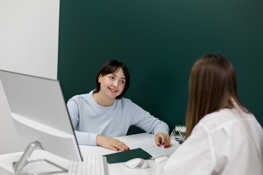 Smiling client discussing with saleswoman in office