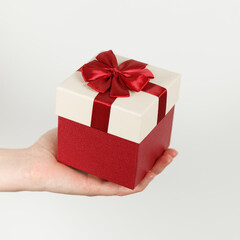 Gift with a bow in hand. Surprise, congratulations on the holiday.