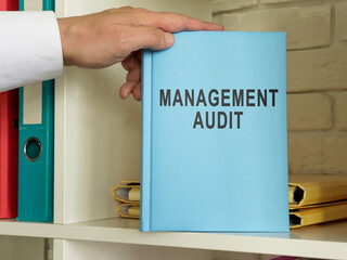 Management audit guide book on the shelf.