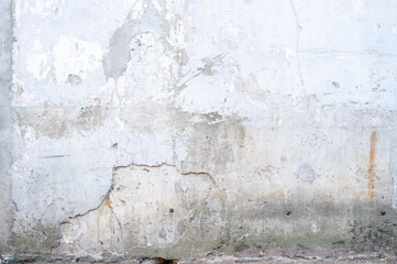 Wall with peeling plaster and peeled paint, outdoors. Copy space. Abstract background. 