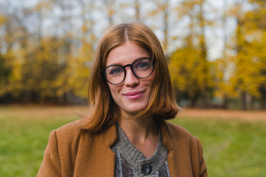 Beautiful woman with eyeglasses smiling at park
