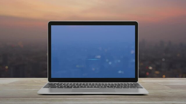 Download flat icon on modern laptop computer screen on wooden table over blur of cityscape on warm light sundown, Technology internet online concept