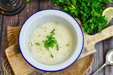 Home made chicken soup with noodles ,parsley and vegetables in white bowl . Healty soup