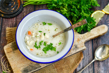 Home made chicken soup with noodles ,parsley and vegetables in white bowl . Healty soup