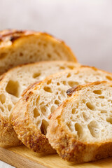 Close up of slices of freshly baked wheat bread on wooden board, selective focus.