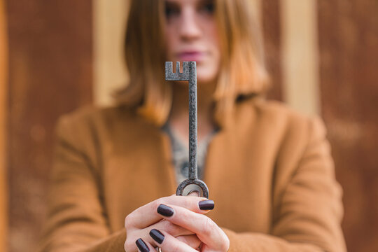 Young woman holding old key