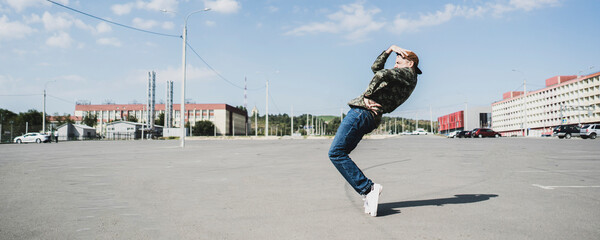 athletic young guy dancing hip-hop outdoors in the street