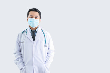Fototapeta na wymiar Smiling male doctor in lab clothes hand in pocket wearing a mask with white background