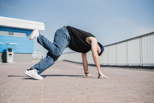 person perfoming breakdance in the street outdoors, bboy stance