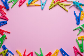 Colorful clothespins on the pink flat lay background with copy space. Top view.