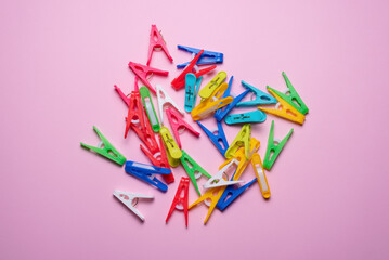 Colorful clothespins on the pink flat lay background. Top view.