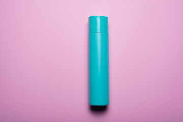 Hair shampoo bottle on the pink flat lay background. Top view.