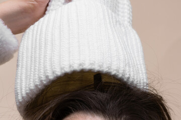 Woman takes off her hat and her hair is electrified close up concept.