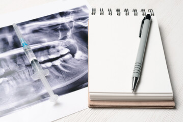 Blank page notepad with copy space and x ray teeth snapshot on the table. Dentist notes concept....