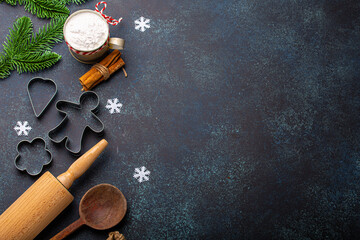 Christmas and New Year festive baking background with kitchen tools, flour, fir tree branch, metal cookie cutters on dark blue stone concrete background table top view, space for text frame - Powered by Adobe