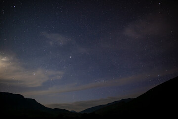 Beautiful night landscape. Starry sky and silhouette of mountains. Wildlife.