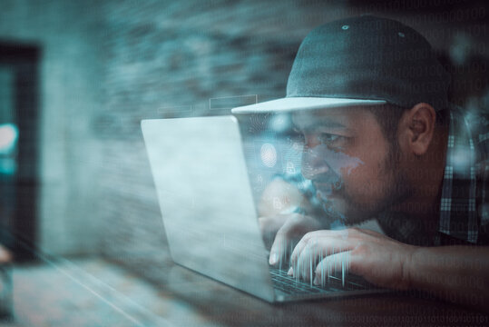 Hacker in black hoodie using laptop on the desk to hacking system with binary code and upload the malware with virtual screen display binary code, bar graph and world maps on the background