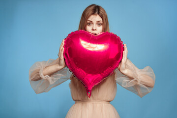 pretty woman red heart in the hands of the balloon blue background