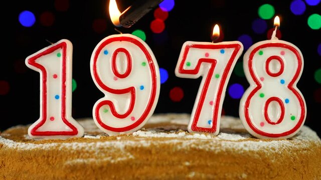 Birthday cake with white burning candles in the form of number 1978