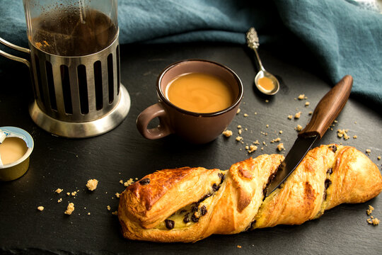 geb&auml;ckstange mit pudding und schokolade gef&uuml;llt und eine tasse espresso mit kaffekanne und milch