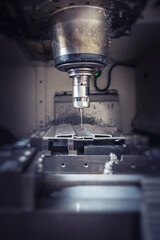 A heavy industrial worker in a factory works with metal on angle grinders while hot sparks are produced as a result.