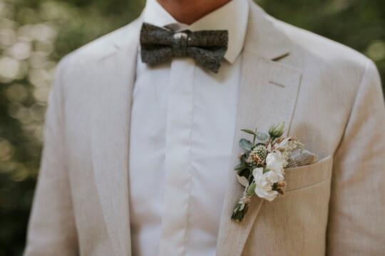 groom in a cream suit with a tie