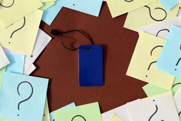 Question marks are drawn on small pieces of paper and folded in a circle. There is a bead tag in...