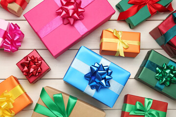 Many colorful gift boxes on white wooden table, flat lay