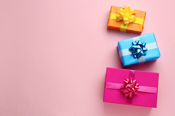 Bright gift boxes on pink background, flat lay. Space for text