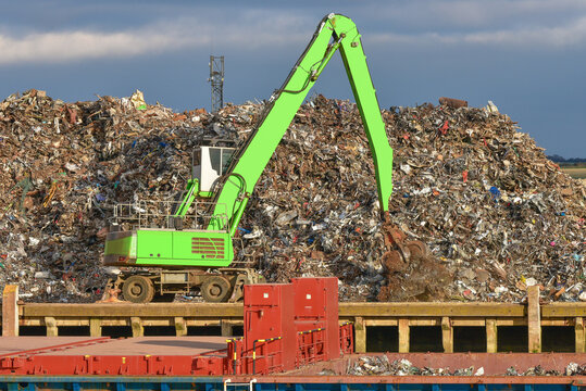 Scrap metal pile waiting for recycling with crane, loading onto ship, Newhaven port, East Sussex - Powered by Adobe