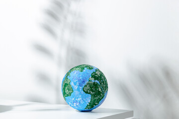 Small globe placed on white table in light room