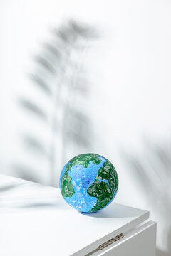 Small globe placed on white table in light room