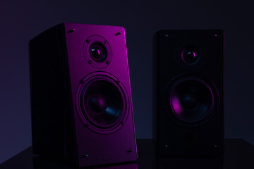 image photograph of the speaker system on a black background with purple atmospheric illumination