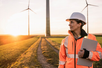 Smiling engineer with digital tablet looking away