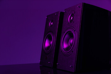 hi-fi speaker set with large speakers on a dark background, purple neon illumination