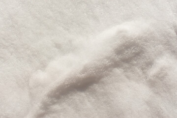Snow texture close-up. Abstract white winter natural background. Mockup for postcard design. websites, covers, booklets. Beautiful shadows on fluffy snowdrifts. Copy space, top view. Purity concept