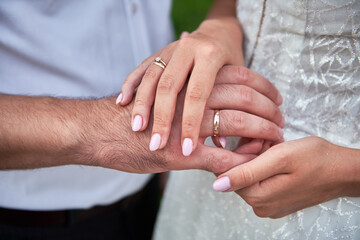 Obraz na płótnie Canvas Newlywed couple's hands with wedding rings, copy space. Wedding couple, bride and groom, hands with rings, closeup
