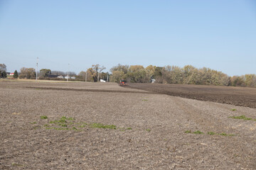 Farmer tilling field in the autumn