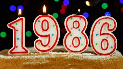 Birthday cake with white burning candles in the form of number 1986