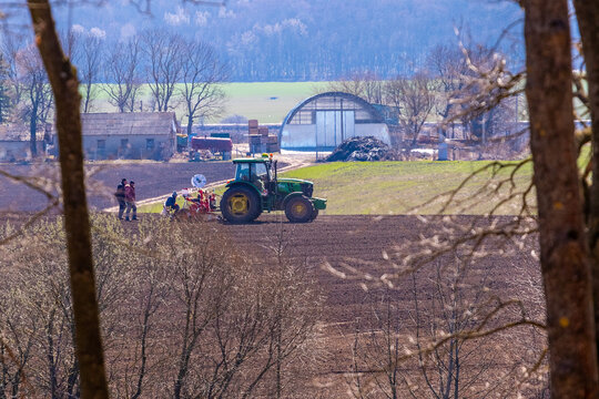Ukraine, Khmelnytsky region, March 2021. Tractor with a seeder in the field during sowing of grain