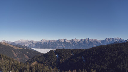 Fototapeta premium wonderful view in the morning with fog in the valley and blue sky on the mountains