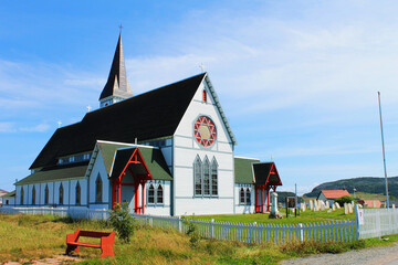 Fototapeta na wymiar St. Paul's Anglican Church, Trinity, Newfoundland, summer. Sunny day, blue sky with light, wispy cloud.