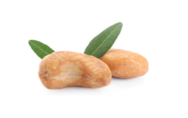 Tasty organic cashew nuts and green leaves isolated on white