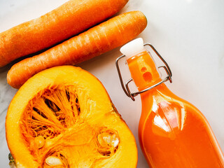 Three bottles with juice, milk, oatmeal and slices of vegetables lying on the table