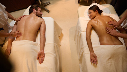 High angle view of adorable newlyweds, heterosexual couple getting body massage therapy at wellness...