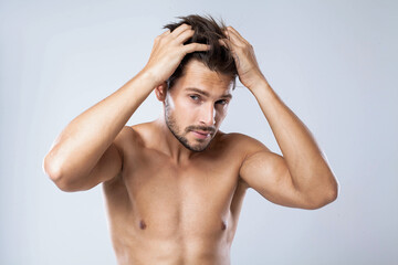 Shirtless handsome man touching his hair with both hand