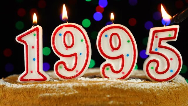 Birthday cake with white burning candles in the form of number 1995